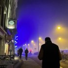 Person walking on dimly lit urban street under starry sky