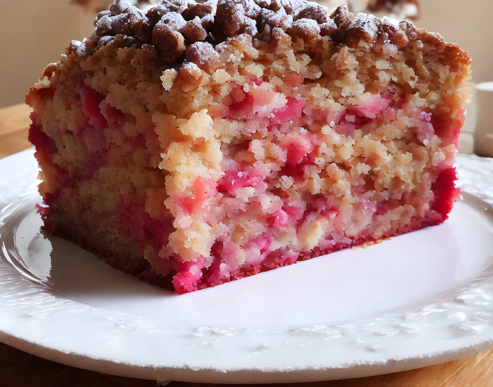 Pink and vanilla layered crumb-topped cake on a white plate