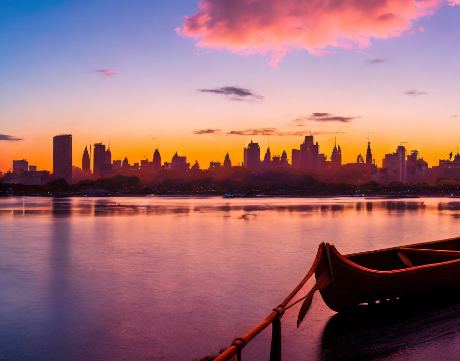 City skyline at twilight with colorful sky reflected in water.