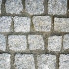 Stone faces with various expressions on sandy textured wall