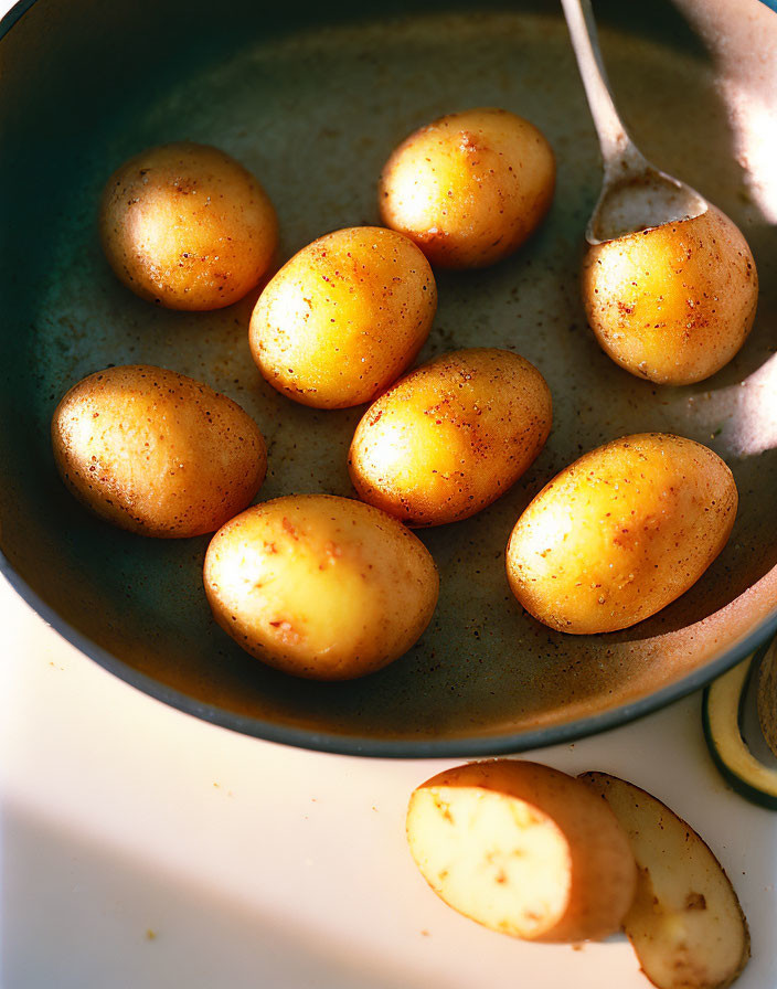 Sliced golden-brown potatoes in a sunlit pan