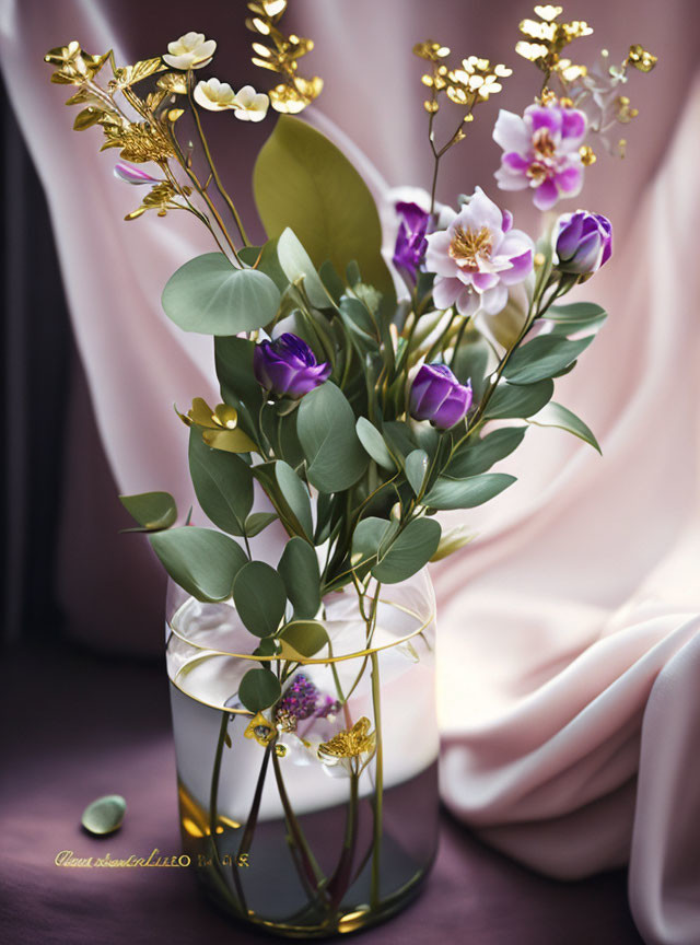 Purple tulips, white & pink flowers in gold-accented vase on pink drapery