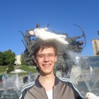 Serene boy with white dove and blue pigeon under clear sky