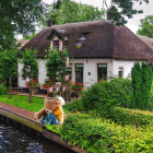 Tranquil Thatched-Roof Cottage by Riverbank with Rowboat
