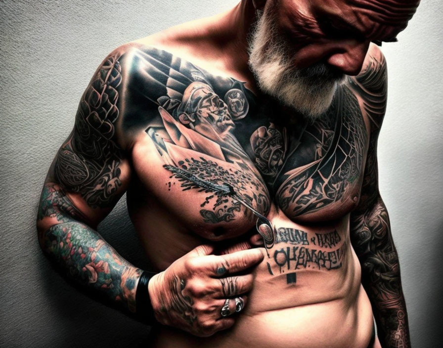 Muscular older man with tattoos, beard, mustache, and thoughtful expression.