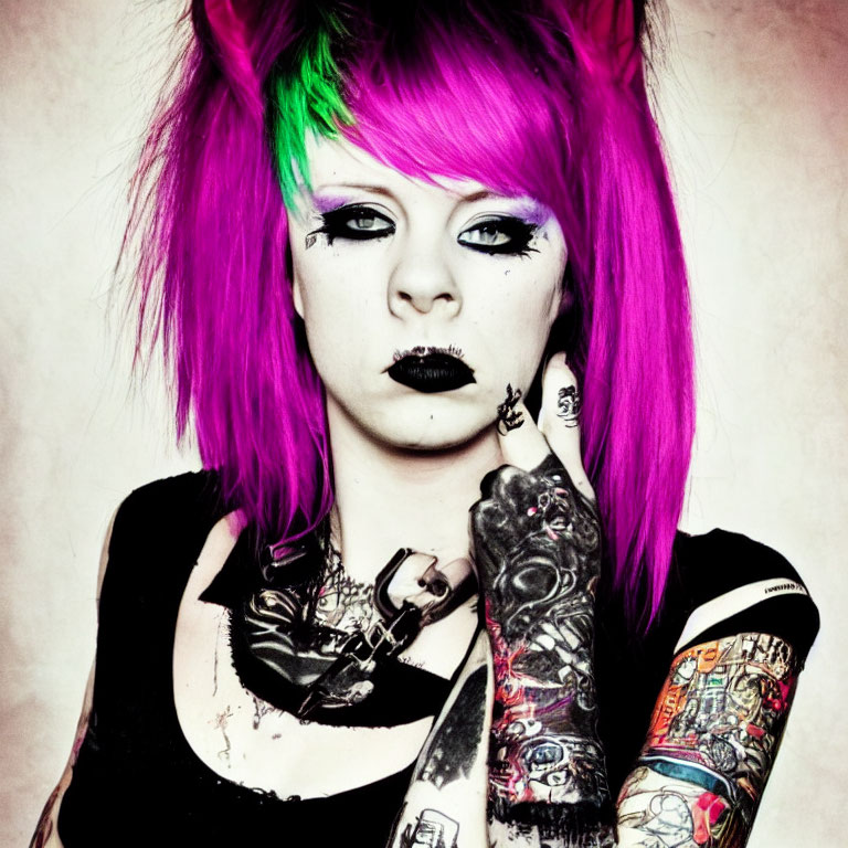 Vibrant pink and green hair, black lipstick, heavily tattooed arms pose in punk/goth