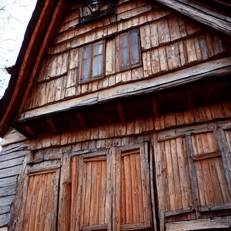 Weathered Wooden House with Small Windows and Gabled Roof