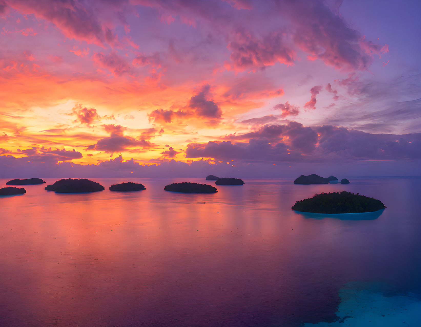 Scenic sunset over calm ocean with islands and colorful clouds