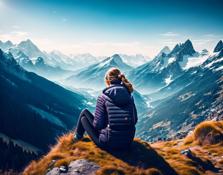 Person Contemplating Snow-Capped Mountain View