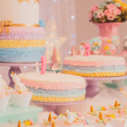 Colorful Stacked Books with Butterflies, Stars, Flowers, and Ribbons on Pink Background