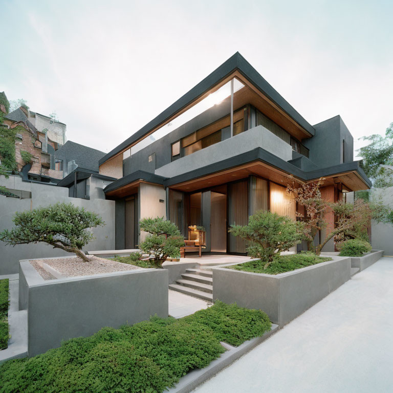 Modern Two-Story House with Dark Gray Facade and Large Windows in Landscaped Setting