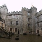 Detailed digital illustration of grand castle courtyard with high walls, circular towers, and intricate brickwork