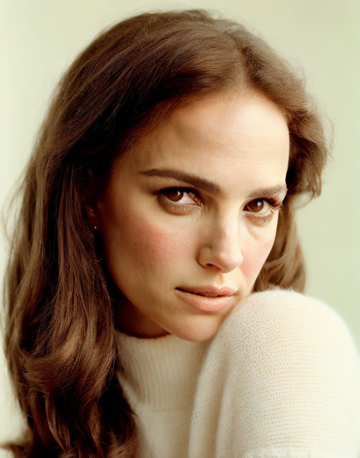 Close-up Portrait: Woman with Brown Hair and Intense Gaze in White Knit Top