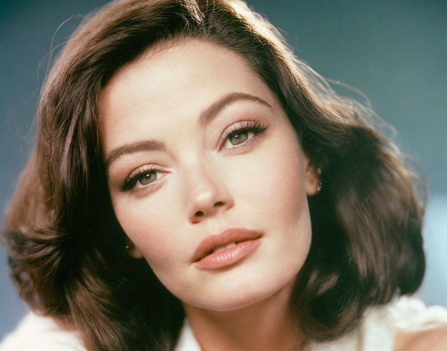 Portrait of woman with dark hair and fair skin gazing intently.