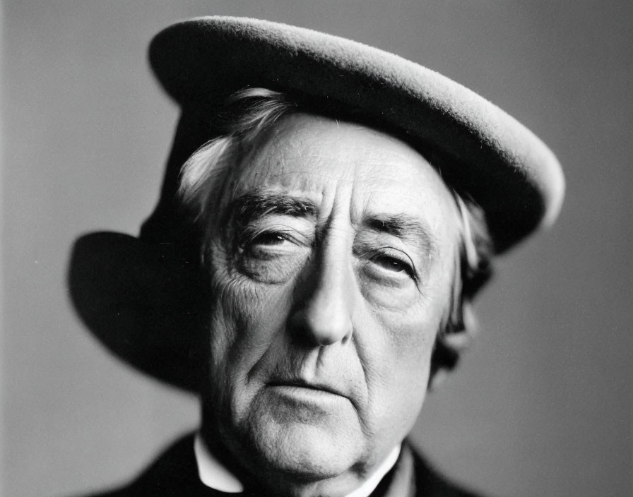 Monochrome portrait of elderly man in beret and dark coat