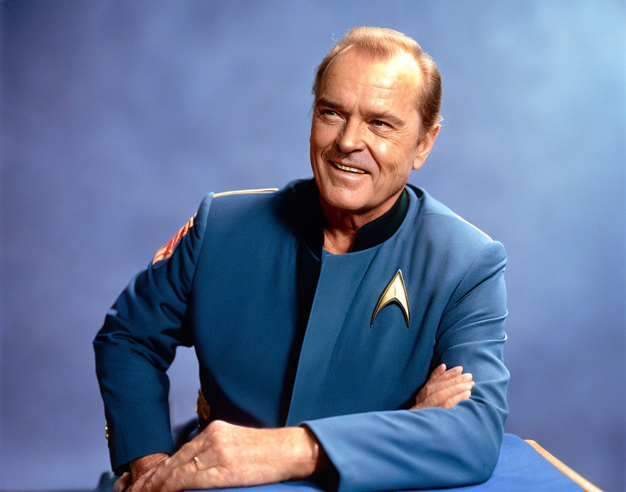 Man in Blue Starfleet Uniform with Communicator Badge Smiling Against Blue Background