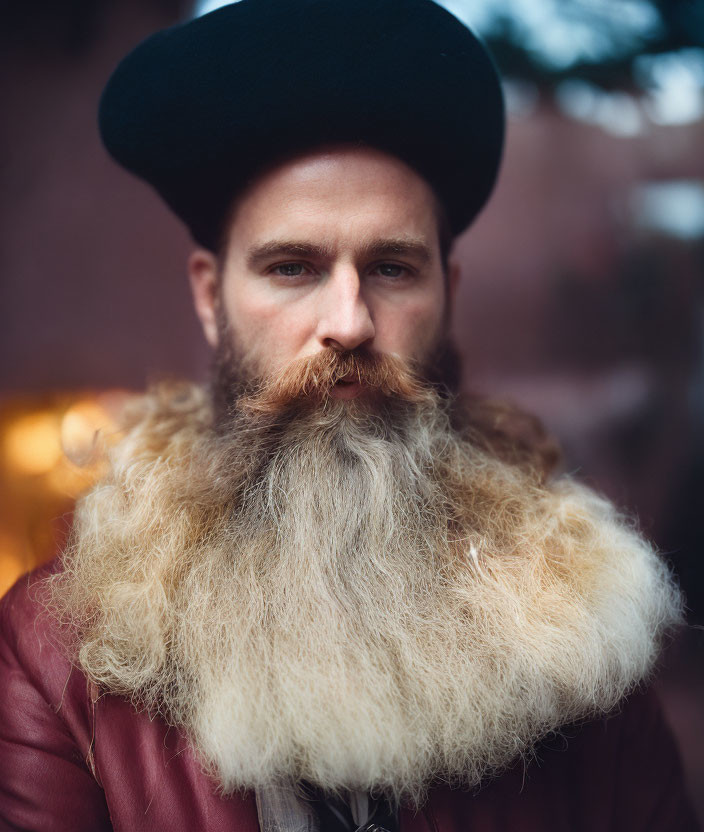 Stylish man with voluminous beard in beret and leather jacket