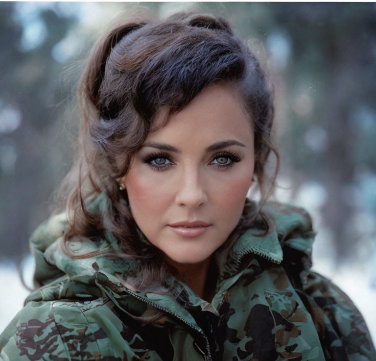 Woman with Blue Eyes and Camouflage Jacket in Snowy Background