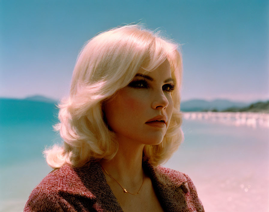 Blonde woman looking at calm sea and sky