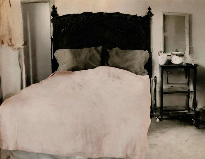 Vintage double bed, ornate headboard, and antique stove in room.