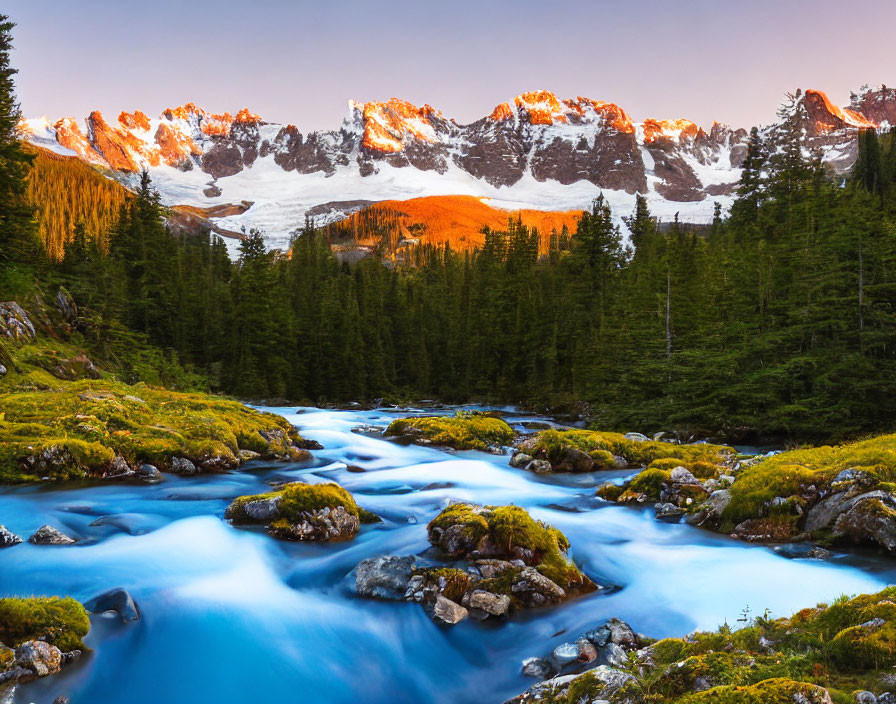 Tranquil stream in green landscape with blue waters and snow-capped peaks