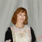 Smiling woman in vintage floral dress on white backdrop