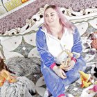 Young girl with bow and bunny surrounded by Easter eggs and plush rabbits in spring theme