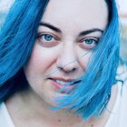 Woman with Blue Paint Flowing in Hair and Colorful Specks