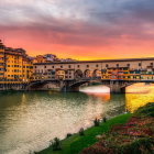 European-style town with historic buildings and stone bridge at sunset