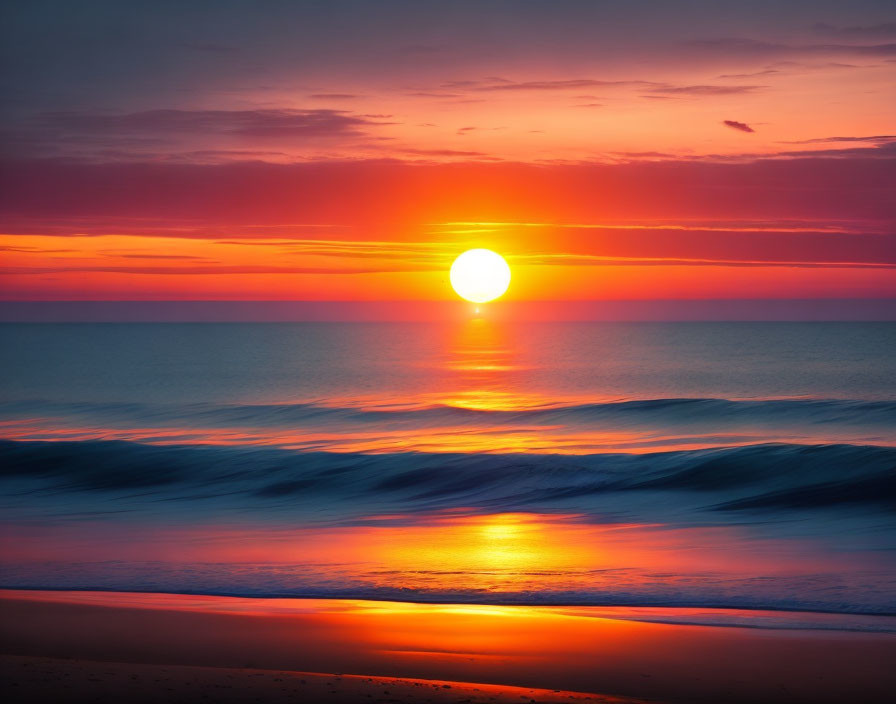 Vibrant Orange Sunset Over Ocean with Waves Approaching Beach