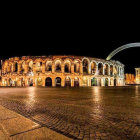 Quaint cobblestone street at night with white buildings and crescent moon