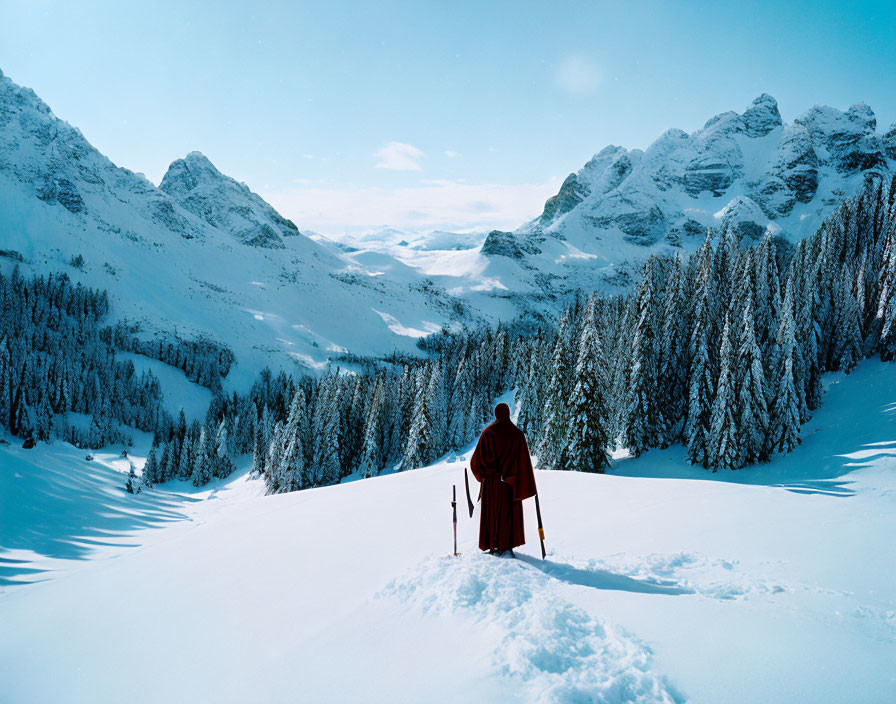 Solitary figure in red cloak on snowy ridge gazes at alpine landscape