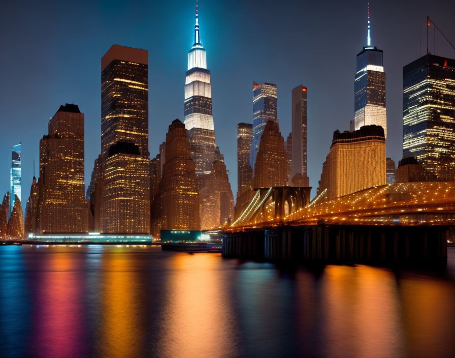 Nighttime New York City skyline with illuminated skyscrapers reflected in water