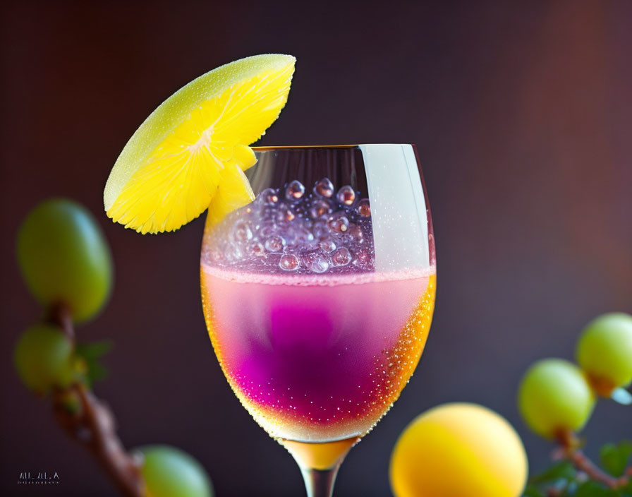 Pink and Yellow Gradient Drink with Lemon Slice and Bubbles on Green Grape Background