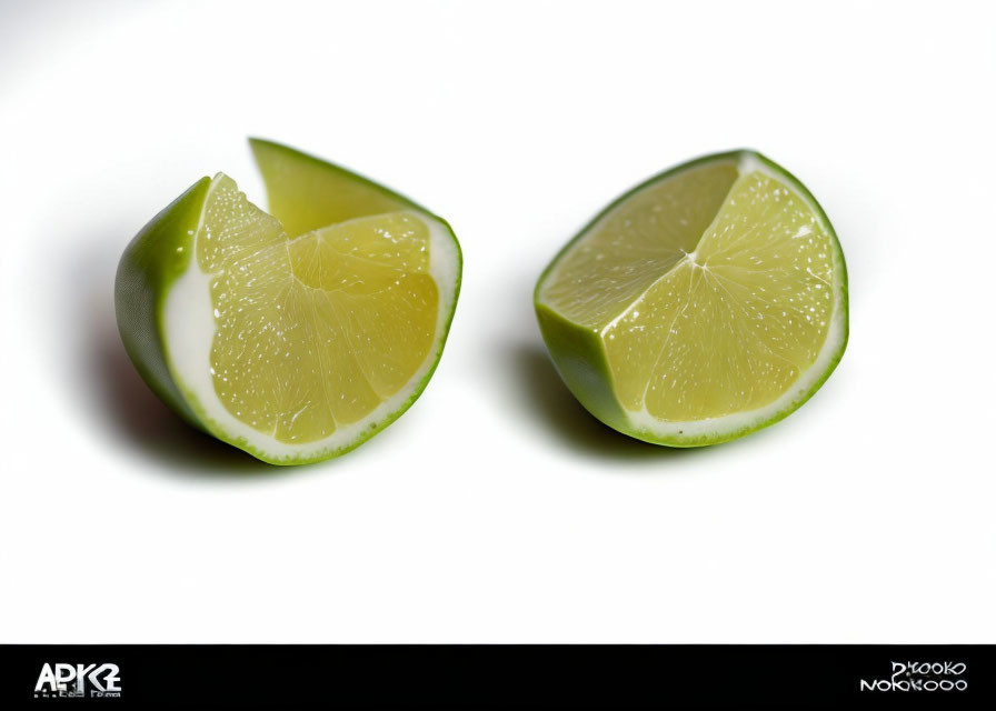 Two Fresh Lime Wedges on White Background Showing Juicy Interior