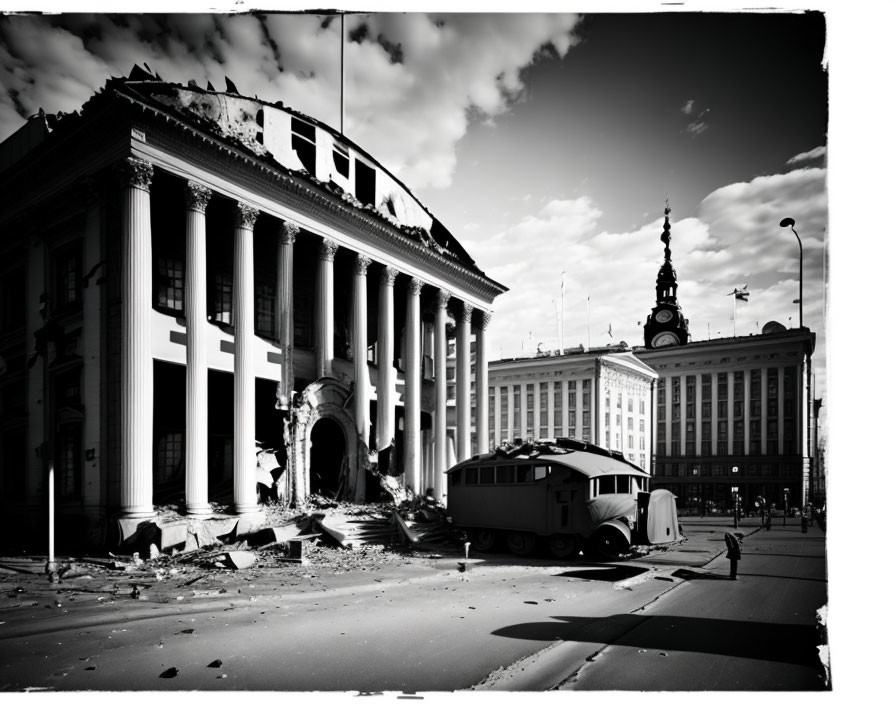 Monochrome image of damaged classical building with columns, debris, caravan, and cloudy sky