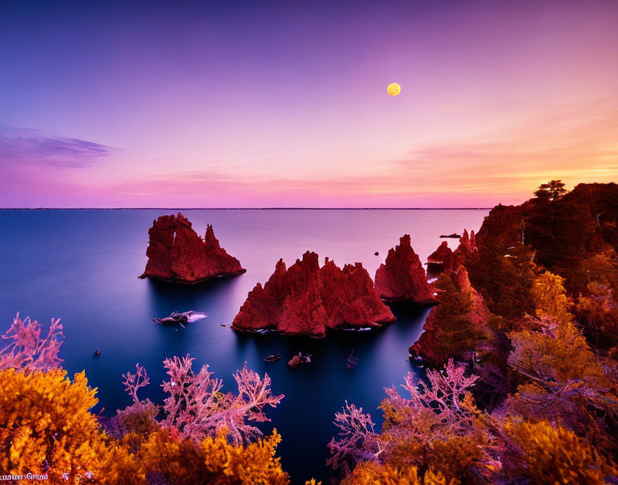 Tranquil dusk seascape with purple and pink skies, full moon, rocks, and lush foliage