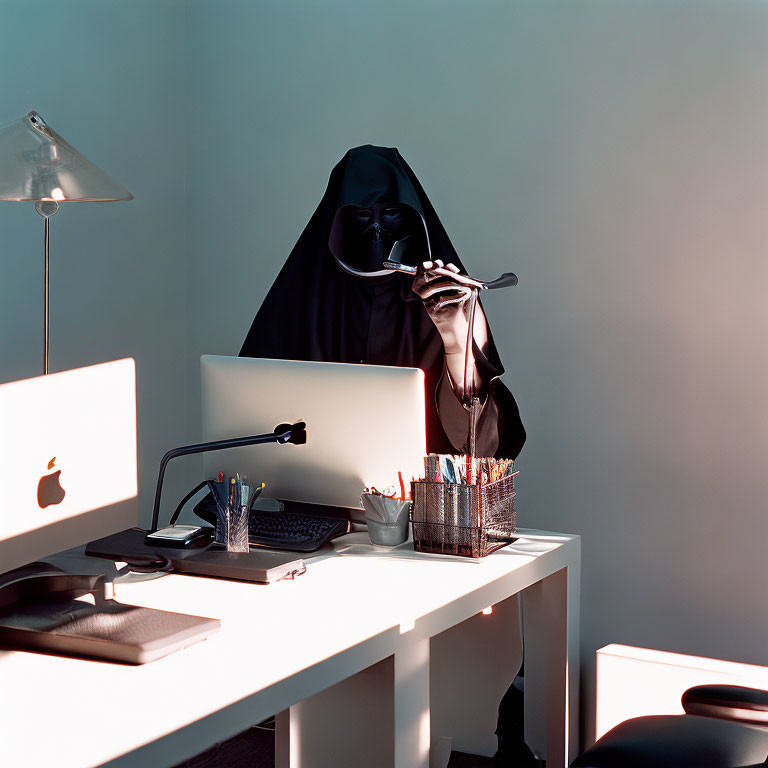 Person in Grim Reaper Costume Using Computer at Modern Office Desk