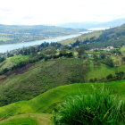 Scenic landscape with cottages, meadows, lake, and mountains