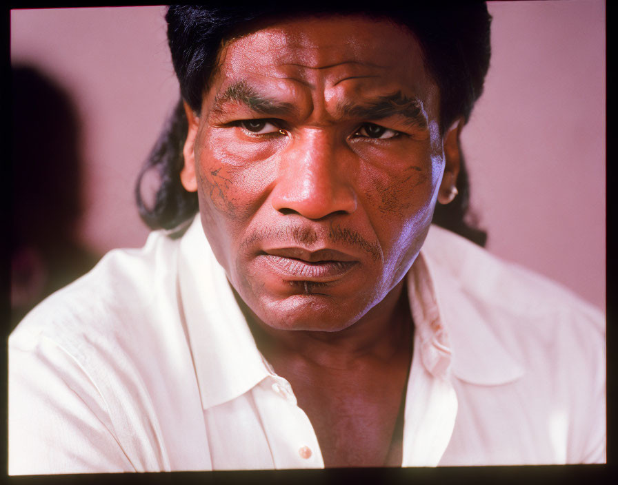 Close-Up Shot of Man with Distinctive Facial Tattoos and Dark Hair