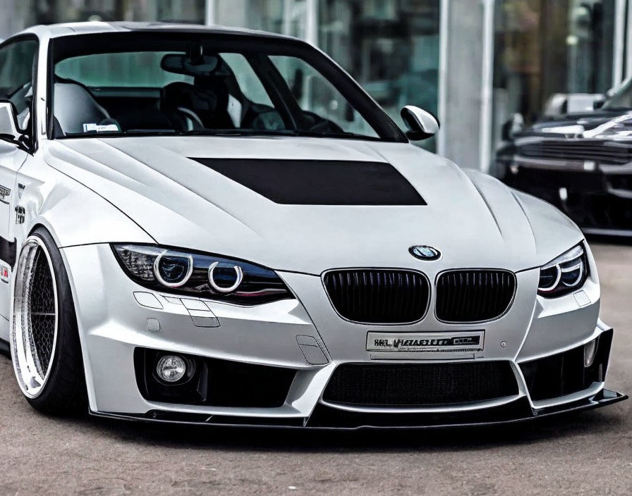 Custom White BMW with Modified Front Bumper and Hood Vents parked in Lot