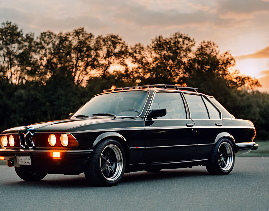 Black Sedan Car Parked at Dusk with Headlights On