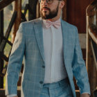 Bearded man in light blue suit standing in rain with pensive expression