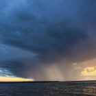 Lighthouse in stormy sea under dramatic sky