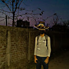 Character in White Shirt and Cowboy Hat Against Starry Night Sky