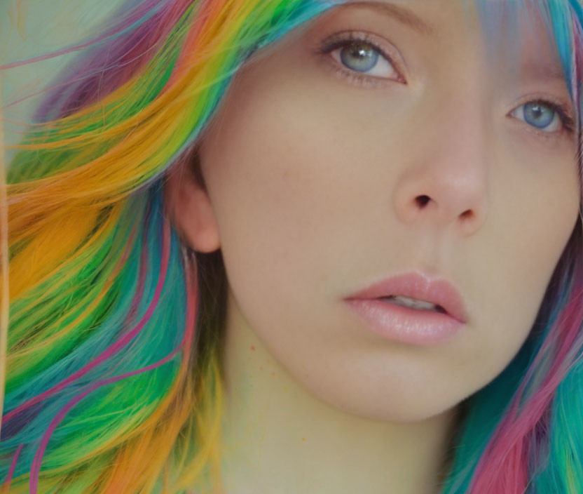 Portrait of a person with rainbow hair and blue eyes on fair skin