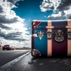 Vintage-Style Suitcase on City Street with Cars and Cloudy Skies