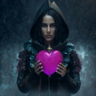 Mysterious Woman with Glowing Pink Heart in Dark Cloak