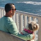 Man and woman relaxing on balcony by the sea on a sunny day