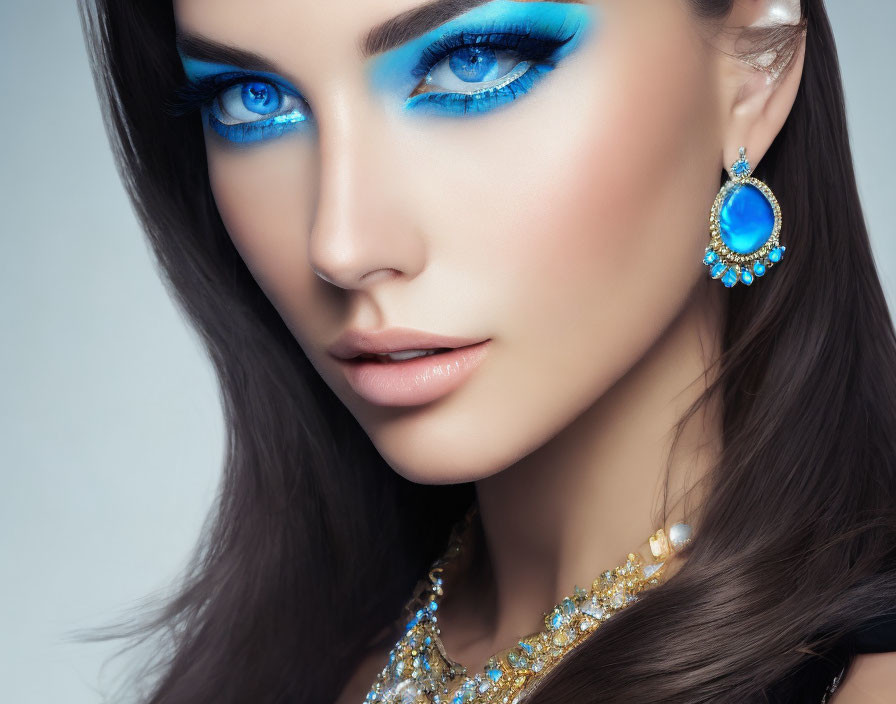 Woman with Striking Blue Eye Makeup and Matching Earrings, Golden Necklace